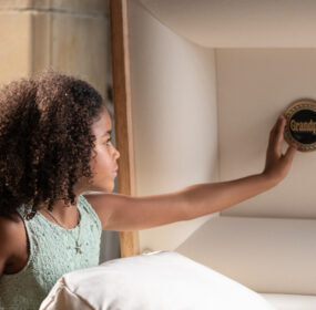 Young girl touching medallion in casket cap panel