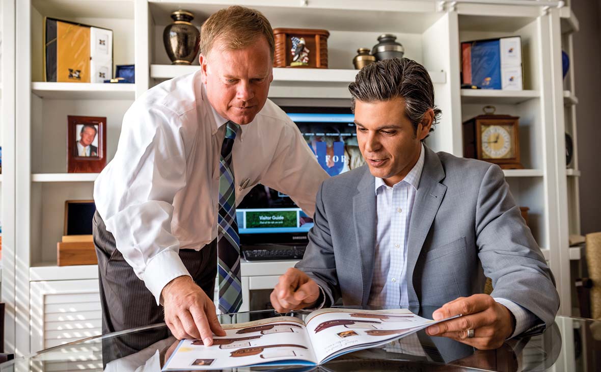 Two gentlemen reviewing Batesville catalogs